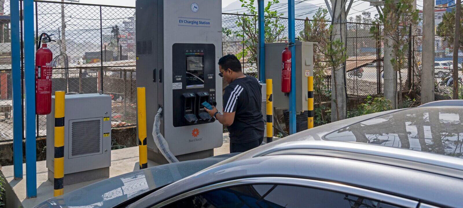 Man Paying After Charging an Electric Car at an NEA Charging Station